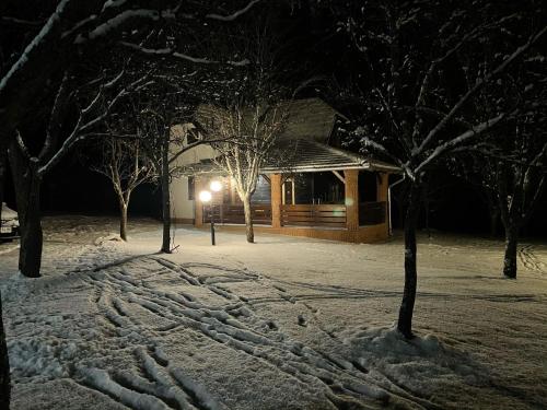 a log cabin in the snow at night at Seosko domaćinstvo Bondžulić in Užice