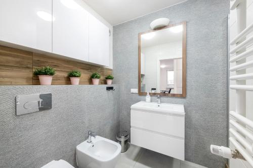 een badkamer met een toilet, een wastafel en een spiegel bij Waw Pokoje Manhattan in Warschau
