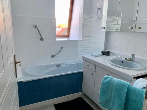 La salle de bains est pourvue d'une baignoire, d'un lavabo et d'un miroir. dans l'établissement Ninou Cap Sud, terrasse vue mer, appt lumineux 66m2, à Wimereux