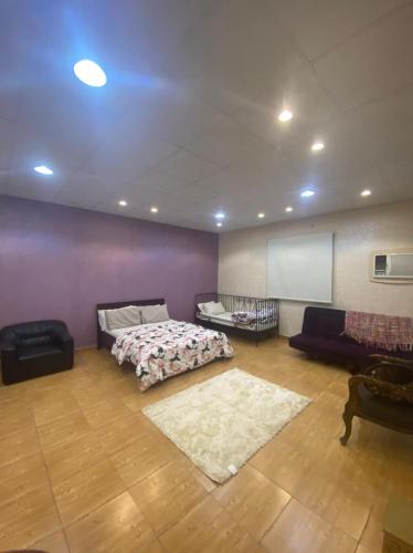 een grote kamer met een bed en een bank bij استراحة الماس in Umm Lajj