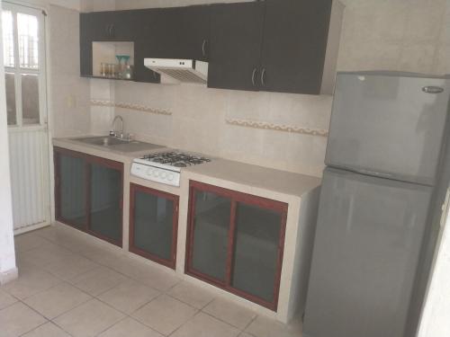 a kitchen with a stove and a refrigerator at Casa con alberca!! Ixtapa Zihuatanejo in Zihuatanejo