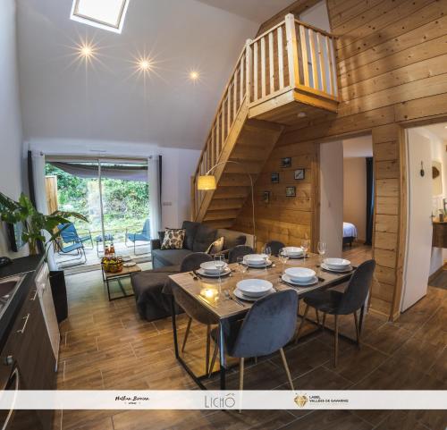 a dining room and living room with a table and chairs at Le Nid Montagnard in Aucun