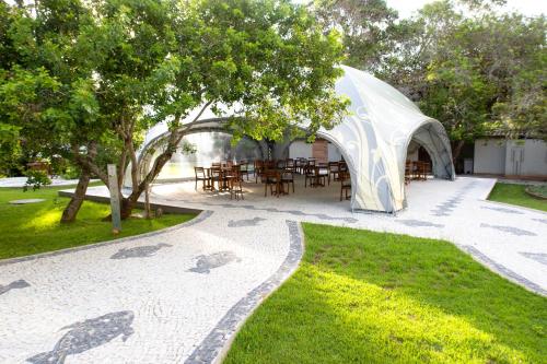 a gazebo with tables and chairs in a park at Pousada Aguas Claras in Búzios