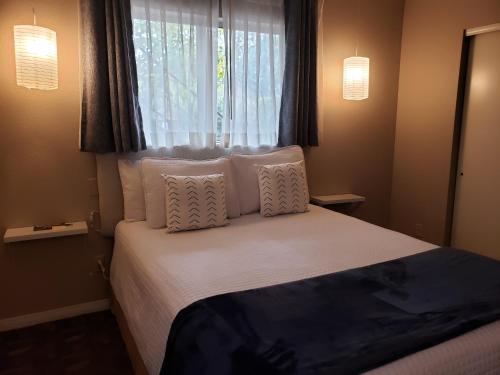 a bedroom with a bed with white pillows and a window at Baby Quail Inn in Sedona