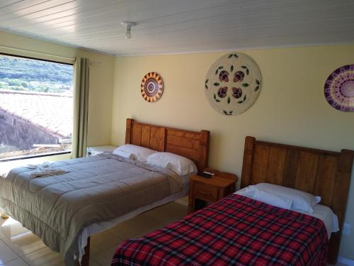 a bedroom with two beds and a window at Cafe Preto Pousada e Bistrô in Mucugê