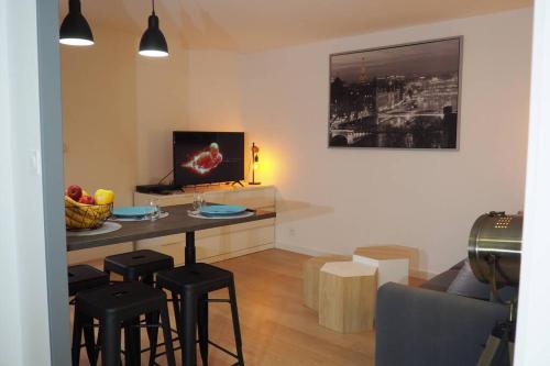 - un salon avec une table et des tabourets dans l'établissement Le Faubourg-Raines - Chaleureux studio à 5mn de la gare, à Dijon
