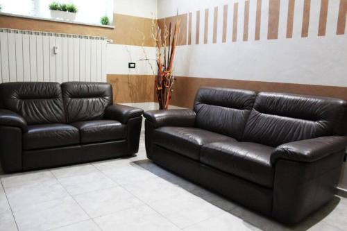 two black leather couches in a waiting room at Casa Chanoux in Turin