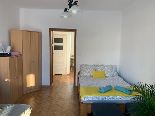 a bedroom with a bed with yellow and blue pillows at White Apartment House in Bielsko-Biała