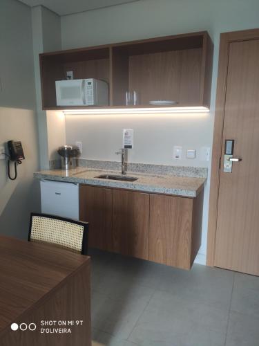 a kitchen with a sink and a microwave at Salinas Exclusive Resort in Salinópolis