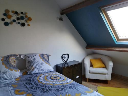 a bedroom with a bed and a chair and a window at GITE DE LA BUTTE le charme de la Normandie entre Terre et Mer in Condé-sur-Vire