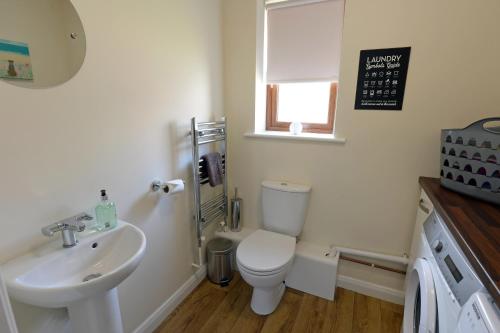 a bathroom with a white toilet and a sink at Coppins Park in Pembrokeshire