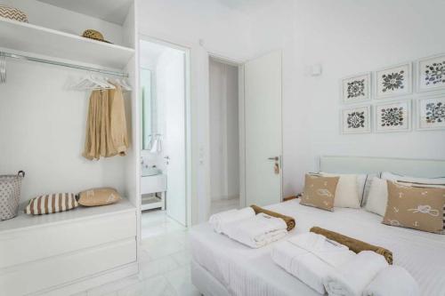 a white room with a bed and a mirror at Seashore Beachfront Villa in Lachania