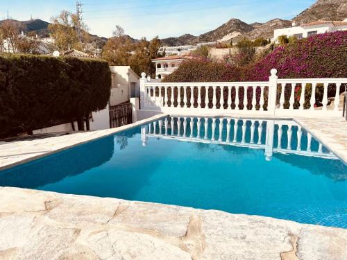 a swimming pool with a white fence and blue water at Super Exclusive Bungalow in Benalmádena