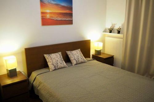 a bedroom with a bed with two lamps on it at Wilanów Apartment close to Town Hall and Palace in Warsaw