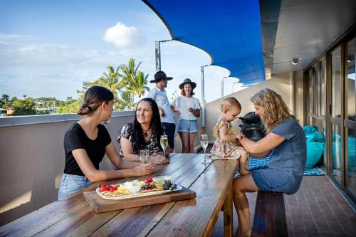 a group of people sitting around a table on a balcony at Heart of Airlie Beach Apartment in Airlie Beach