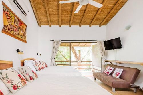 a bedroom with two beds and a flat screen tv at Dreamcatcher Hotel - Atrapasueños in Santa Teresa Beach