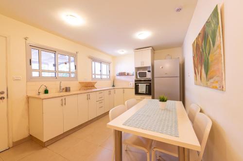 a kitchen with a table and a refrigerator at רגע ערבה in ‘En Yahav