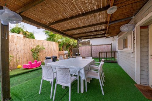 a patio with a table and chairs on the grass at רגע ערבה in ‘En Yahav