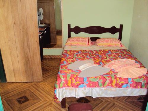 uma cama com um edredão colorido num quarto em Sitio Sao Benedito em São Roque de Minas