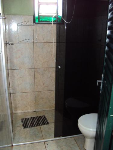 a shower with a glass door and a toilet at Sitio Sao Benedito in São Roque de Minas