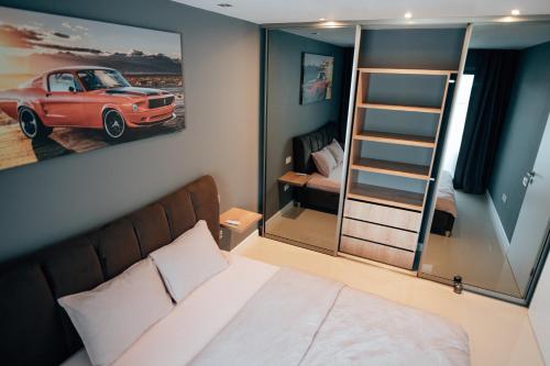 um quarto com uma cama e uma pintura de um carro na parede em Thome Arena Residence em Cluj-Napoca