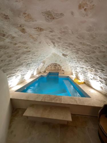 a swimming pool in a cave with a stone wall at LE SPA INSOLITE DE MALAUCENE in Malaucène