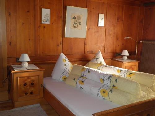 un sofá en una habitación con paredes de madera y 2 lámparas en Alpenhaus Waldberg, en Schruns