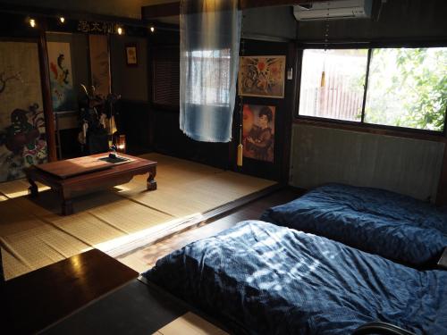 a bedroom with two beds and a table in it at 民泊カフェ Gootarian in Kumamoto