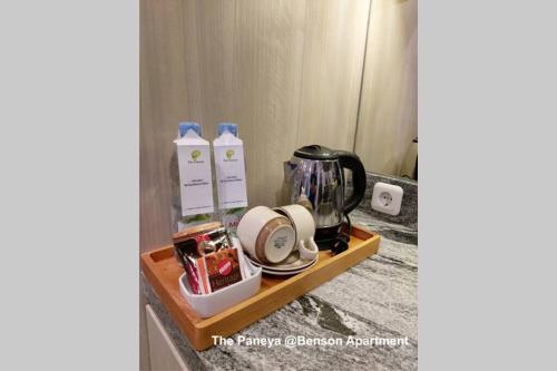 a shelf with a coffee maker and other items on it at The Paneya @Benson Apartment in Surabaya