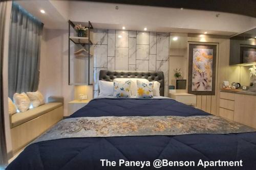 a bedroom with a large bed with a blue comforter at The Paneya @Benson Apartment in Surabaya