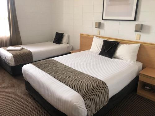 a hotel room with two beds in a room at Narwee Hotel in Narwee