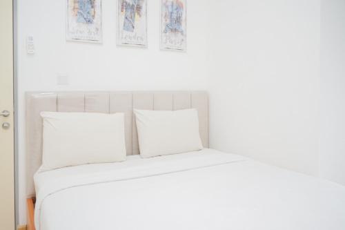 a bed with white sheets and pillows in a room at Great Choice 2BR Apartment at M-Town Residence By Travelio in Tangerang