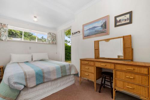 En eller flere senger på et rom på Winstone Cottage - Waterfront Lake Tarawera Home