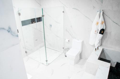a white bathroom with a shower and a toilet at Ramë Hotel Boutique in Guadalajara