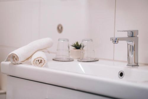 a bathroom sink with a towel and a faucet at Sleep Point - Self Check in Hotel in Bremen