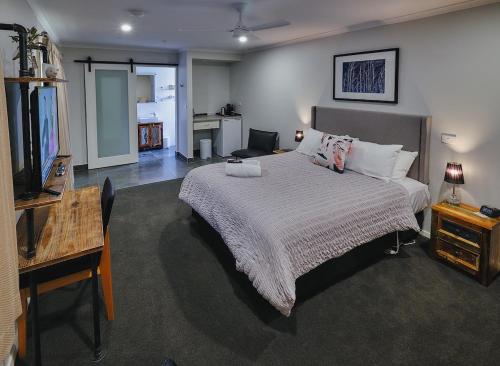 a bedroom with a bed and a desk and a television at Edlin House in Bright
