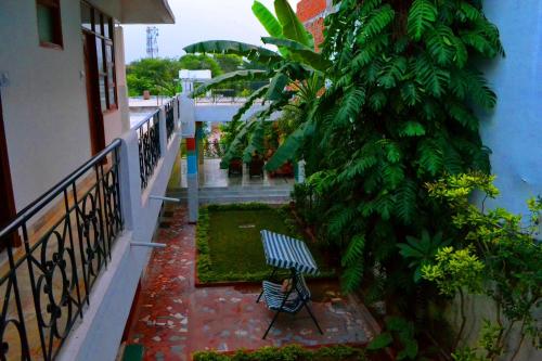 a balcony with a bench next to a tree at Hotel Harmony in Khajurāho