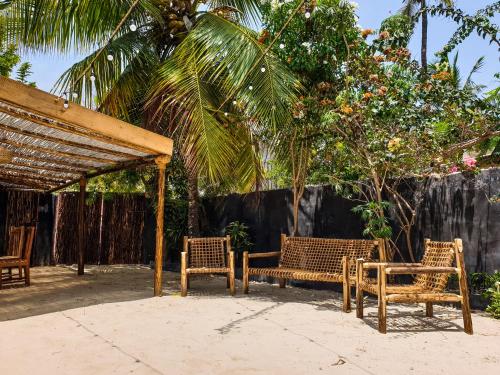 a group of chairs and a table in a patio at Déjà Blue in Paje