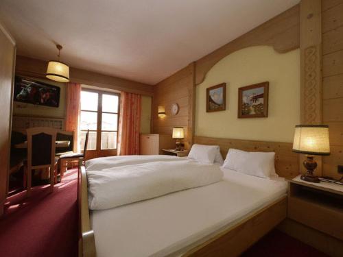 ein Schlafzimmer mit einem großen weißen Bett in einem Zimmer in der Unterkunft Parkhotel Sölden in Sölden