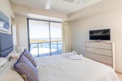 a bedroom with a large bed with a large window at The Waterford Prestige Apartments in Caloundra