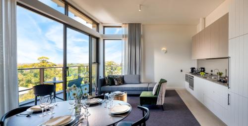 uma cozinha e sala de estar com mesa e cadeiras em Majestic M Suites em Adelaide