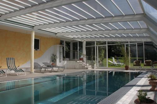 a pool with a pergola and a swimming pool at Gasthof-Pension Zum Haugstein - Familie Eder in Engelhartszell