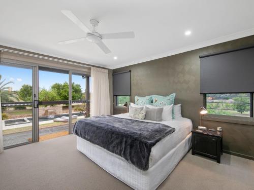a bedroom with a large bed and a large window at Lilies Luxe Suite on Lovedale with Private Heated Pool 5star in Lovedale
