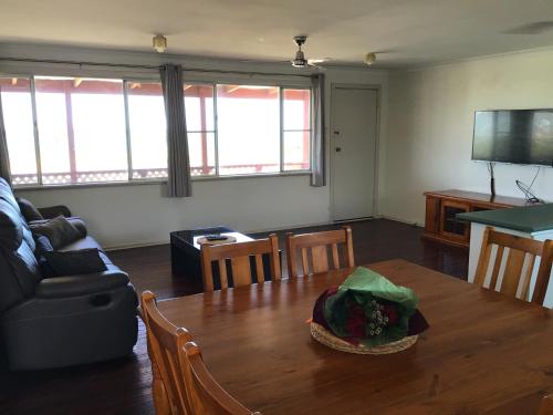 ein Wohnzimmer mit einem Tisch und einem Sofa in der Unterkunft Best Beach Villa in Denham