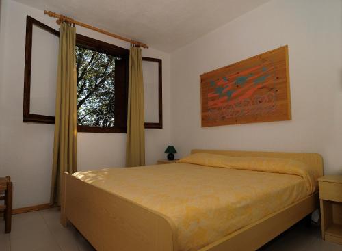 sypialnia z łóżkiem i oknem w obiekcie Residence Portorotondo Tre w mieście Porto Rotondo