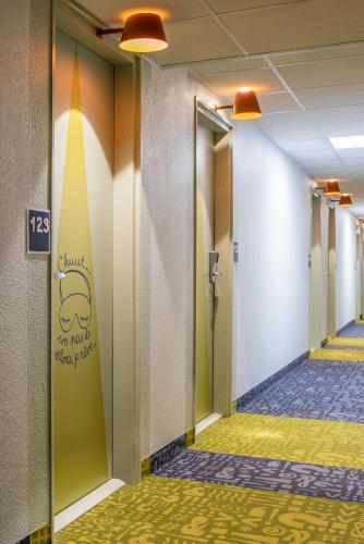 a hallway of a hospital with a surfboard on the wall at ibis budget Saint-Ouen-l'Aumône in Saint-Ouen-lʼAumône