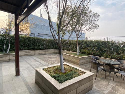 a tree in a planter with a table and chairs at Yushan Town Tianji Cloud Business Hotel in Changshu
