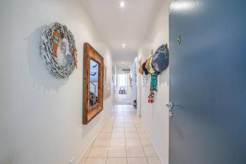 a hallway with paintings on the walls and a door at Saltwater 5 - sleeps 8 - close to Main Beach in Point Lookout