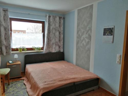 een kleine slaapkamer met een bed en een raam bij Ruhe und Bequemlichkeit in Frauendorf