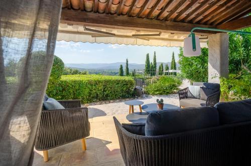 a patio with furniture and a view of a vineyard at Maison Caroline - Villa 10 personnes avec piscine à 5km de Saint Tropez in Saint-Tropez